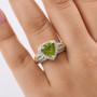 peridot and white zircon trillion halo ring in rhodium over sterling silver worn on a hand