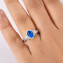 neon apatite and moissanite halo ring in rhodium over sterling silver worn on a hand