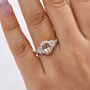 morganite and moissanite halo ring in 18k rose gold over sterling silver worn on a hand