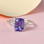 studio display of hackmanite and diamond ring showing vivid purple center stone and sparkling diamonds against pink background