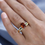 lifestyle image of Madeira citrine, chrome diopside, and zircon ring worn on model’s hand showing vivid gemstone contrast and gold-finished setting