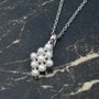angled view of freshwater pearl cluster pendant necklace in rhodium over sterling silver