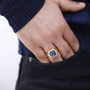 mystic blue petalite and zircon asscher cut halo gents ring in 18k yellow gold over sterling silver worn on a hand
