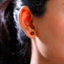 red zircon asscher cut stud earrings in 10k yellow gold shown for size comparison