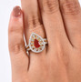 fire opal pear halo ring worn on hand showing moissanite halo and split shank yellow gold design