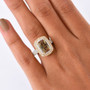 andalusite white and champagne moissanite cushion double halo ring in 18k yellow gold over sterling silver worn on a hand