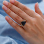 black tourmaline trillion ring with moissanite infinity shank in yellow gold shown on hand