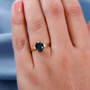 black tourmaline and white zircon accents oval solitaire ring in 18k yellow gold over sterling silver worn on a hand