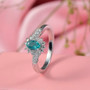 grandidierite and moissanite halo bypass ring in rhodium over sterling silver shown in a lifestyle photo