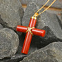 red jade cross pendant necklace in 18k yellow gold over sterling silver shown in a lifestyle photo