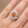 natural orange and white diamond cluster halo ring in 10k yellow gold worn on a hand