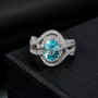 close up of blue zircon and moissanite bypass ring in rhodium over sterling silver