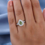 green tourmaline and moissanite pear double halo ring in rhodium over sterling silver worn on a hand