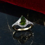 angled view of green tourmaline and diamond pear halo ring in 10k yellow gold