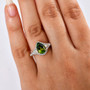 green tourmaline and diamond pear halo ring in 10k yellow gold worn on a hand