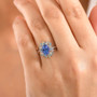 tanzanite and multi color lab diamond oval double halo ring in 10k white gold worn on a hand
