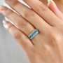 lab blue and white diamond five stone halo ring in rhodium over sterling silver worn on a hand