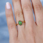 ammolite oval solitaire ring in 18k yellow gold over sterling silver worn on a hand