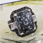 angled view of pinolith black spinel and white topaz ring in rhodium over sterling silver