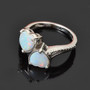 australian white cabochon opal heart bypass ring in rhodium over sterling silver shown in a lifestyle photo