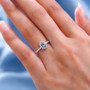 gray spinel oval and moissanite dainty halo ring in rhodium over sterling silver worn on a hand