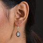 tsavorite garnet sapphire and zircon halo earrings in rhodium over sterling silver worn on the ear