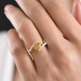 yellow apatite and moissanite bypass ring in 18k yellow gold over sterling silver worn on a hand