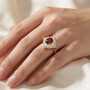red zircon and moissanite halo ring in 18k yellow gold over sterling silver worn on a hand