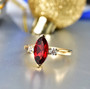 marquise garnet and moissanite three stone ring in 18k yellow gold over sterling silver shown in a lifestyle photo