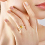 yellow sapphire and diamond halo ring in 14k yellow gold worn on a hand