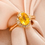 close up of yellow sapphire and diamond halo ring in 14k yellow gold