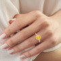 yellow sapphire and diamond halo ring in 14k yellow gold worn on a hand