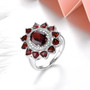 close up of garnet halo ring in rhodium over 925 sterling silver