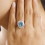 blue zircon and diamond halo ring in 950 platinum worn on a hand