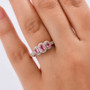 pink spinel oval and moissanite trilogy halo ring in 18k rose gold over sterling silver worn on a hand