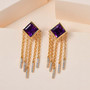 amethyst and moissanite tassel earrings in 18k yellow gold over sterling silver shown in a lifestyle photo
