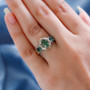 green apatite three stone ring in two-tone 18k yellow gold and rhodium over sterling silver worn on a hand