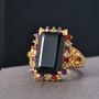 black spinel and multi gemstone halo ring in 18k yellow gold over sterling silver shown in a lifestyle photo