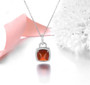 hessonite garnet and white zircon halo necklace in rhodium over sterling silver shown in a lifestyle photo