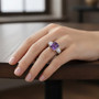 amethyst and moissanite three stone ring in rhodium over sterling silver worn on a hand