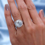white topaz round concave cut halo ring in rhodium over sterling silver worn on a hand