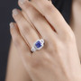 tanzanite and diamond halo ring worn on hand in platinum