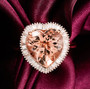 heart morganite and diamond halo ring photographed on fabric in rose gold