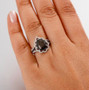 elite shungite pear shaped black spinel and white zircon pear double halo ring in rhodium over sterling silver worn on a hand