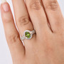 green tourmaline and diamond halo ring in 10k yellow gold worn on a hand