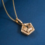turkizite and diamond pentagon cut halo pendant necklace in 14k yellow gold shown in a lifestyle photo