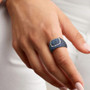 blue sapphire and diamond cluster ring in black rhodium over 18k white gold worn on a hand