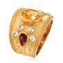 angled view of oval citrine with rhodolite garnet and white topaz ring in yellow gold over sterling silver