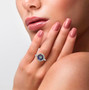 mystic topaz and white zircon round halo ring in rhodium over sterling silver worn on a hand