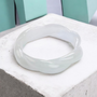 white jade twisted rope solid bangle bracelet shown in a lifestyle photo
